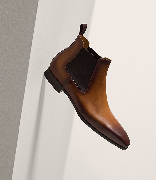A Magnanni Shaw Cuero boot is suspended in mid-air.