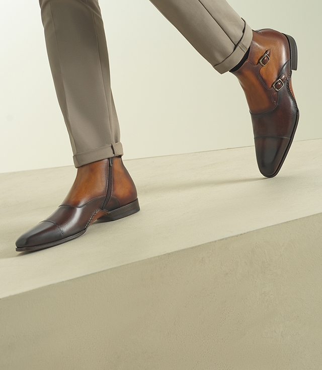 A male model steps forward wearing cuffed beige pants and Magnanni Tronos dress boots. 