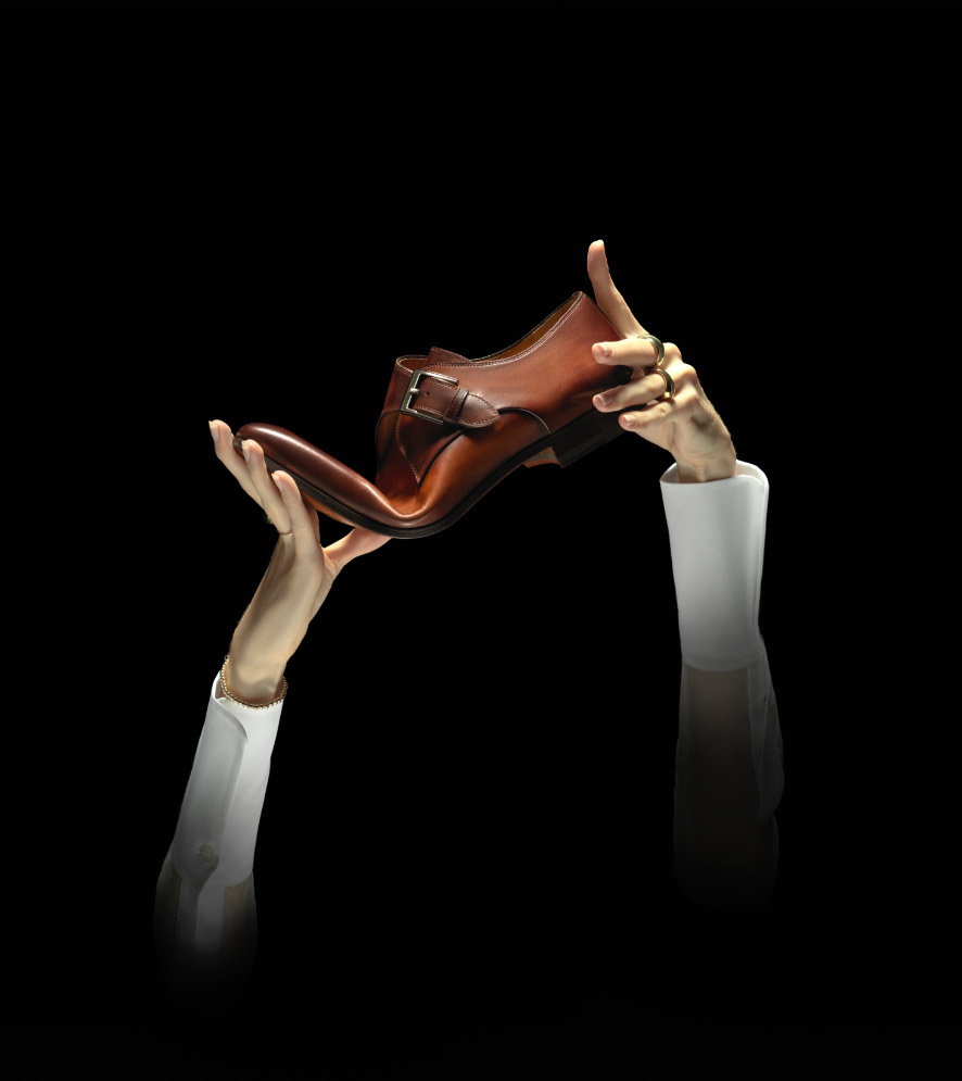 Two disembodied hands bend a Magnanni Bologna constructed shoe.