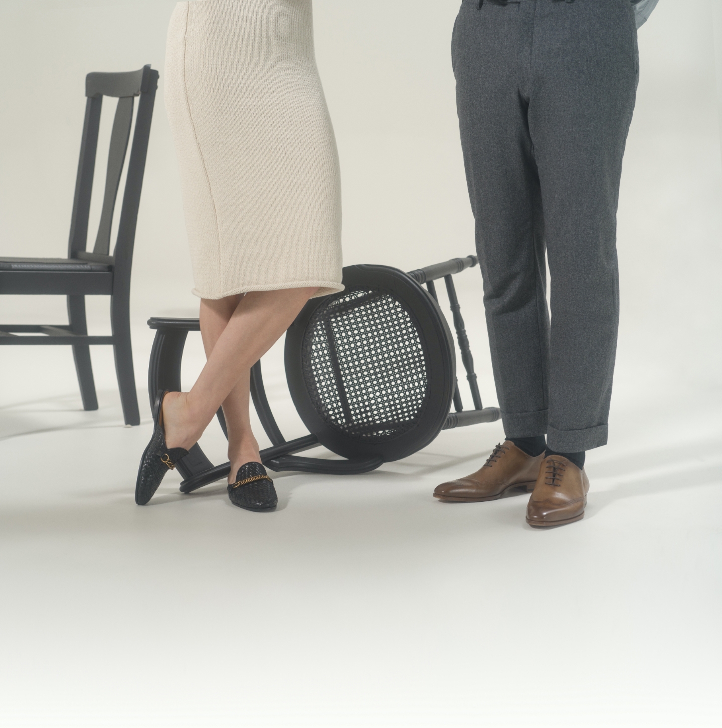 A man and woman stand near chairs while wearing Magnanni Jonas lace-ups and Carmen II loafers respectively.