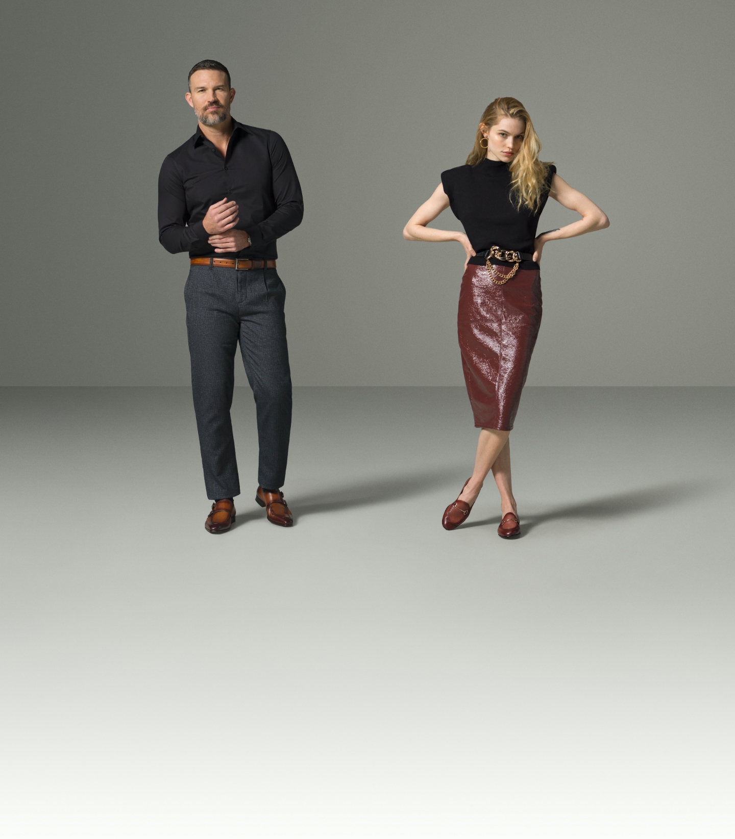 A man and woman stand in an empty room and look at the camera while wearing Magnanni loafers.